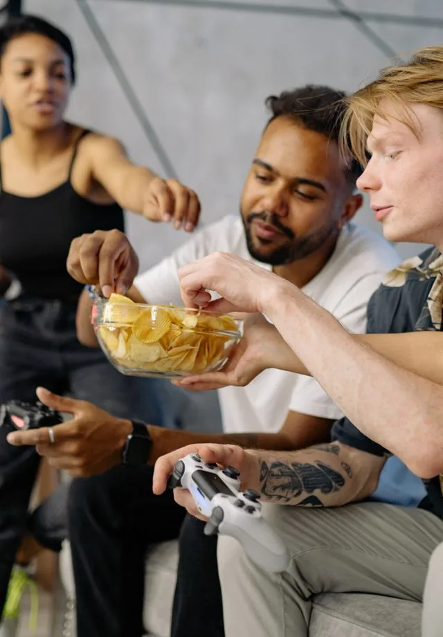 College students sharing CPG brand snacks on a dorm sofa during a group study session